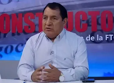 Geremías Escalante con camisa celeste manga larga con fondo del estudio de Tv de El Constructor