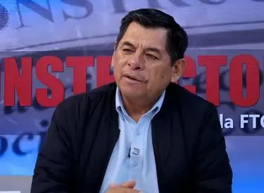Tito Zea en camisa celeste y casaca negra en estudio de Tv 